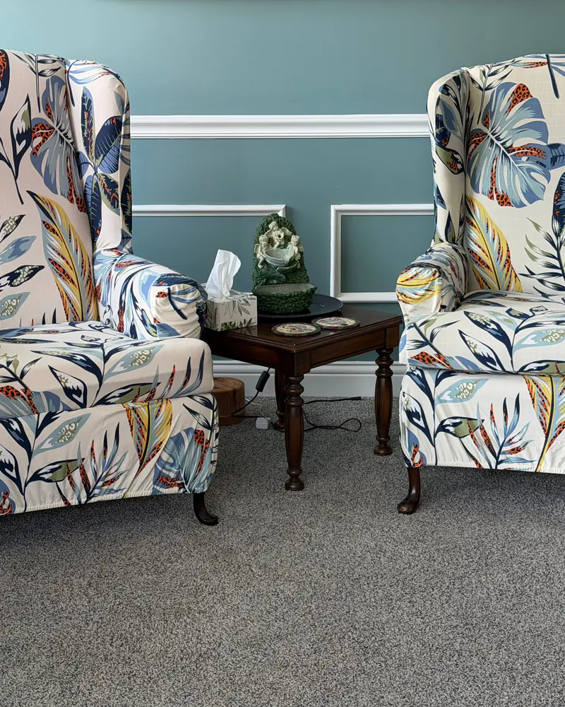 Two patterned wingback chairs beside a side table in the welcome area at 502 E Main Street.
