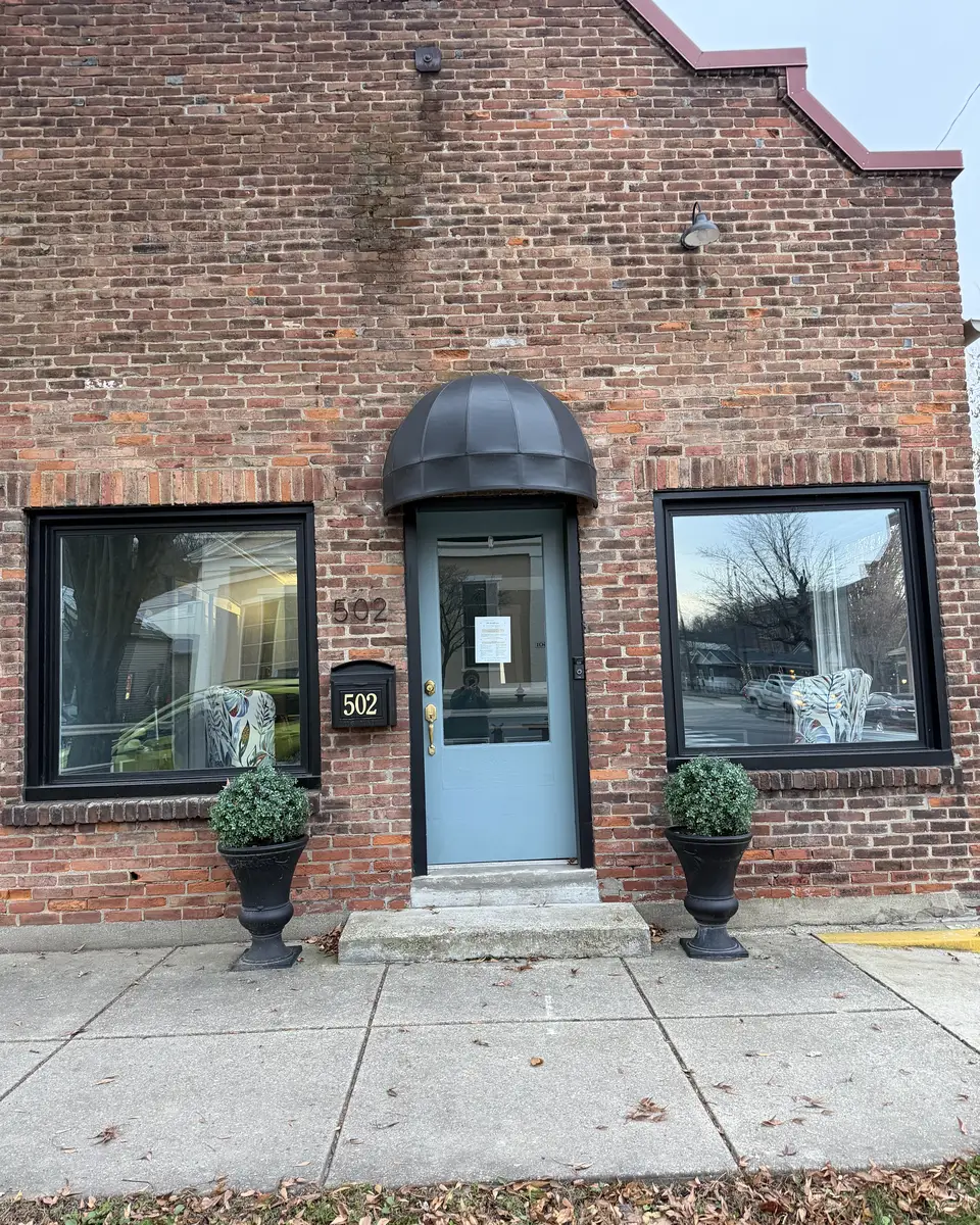 The front of My Oasis 502 on East Main Street: a brick storefront with a dark awning over the door and planters either side of the step.